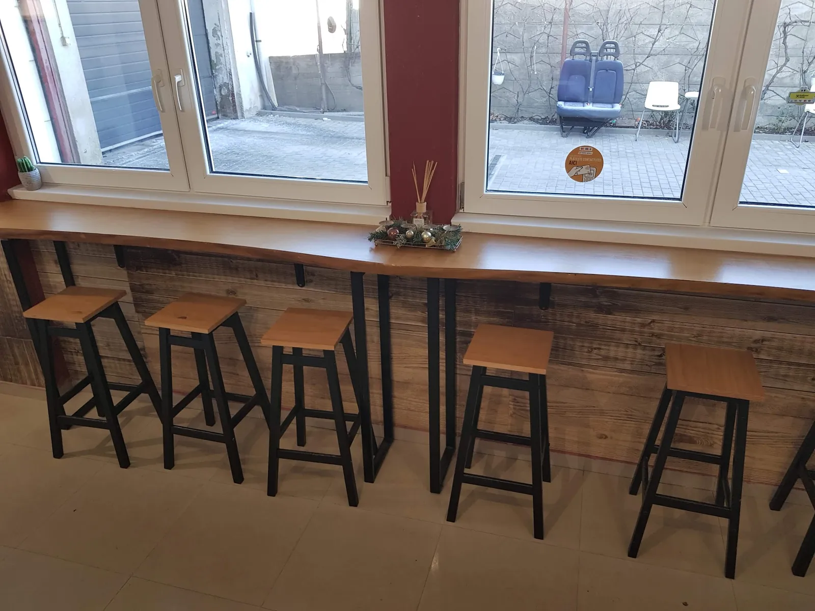 Bar cu scaune înalte la geam, în sala de așteptare