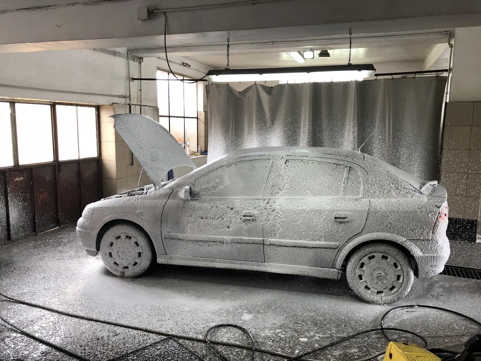 Mașină acoperită complet cu spumă activă în boxa Axi Carwash